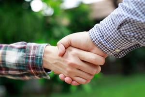 Closeup of a business hand shake between two colleagues Plaid shirt photo