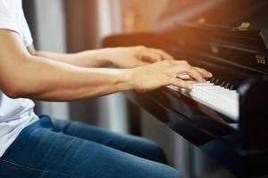 close up of hand people man musician playing piano keyboard with selective focus keys. can be used as a background. photo