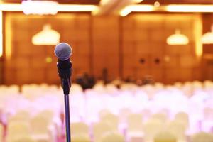 Close up of microphone on stage lighting at concert hall or conference room. copy space banner. soft focus. photo