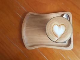 Top view of coffee with heart-shaped latte art from frothy milk and caramel sauce. photo