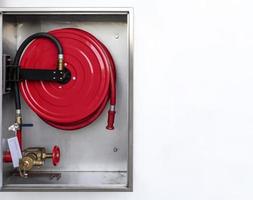 Cabinet open door with fire hose reel inside and copy space photo