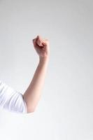 caucasian woman fist hand and tense the arm for showing muscle on white background. photo