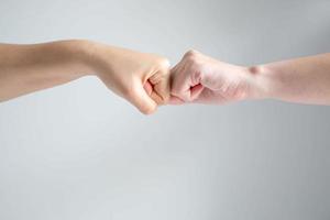 Hand symbol of two fists crash together on white background. photo