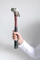 A hand holding hammer hitting forward. photo