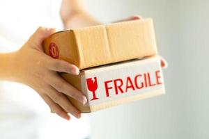 Close-up image of two hands holding two parcel boxes on white background. photo