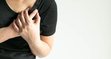 Close-up image of a woman pressing on chest with pain. photo