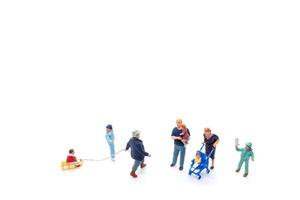 Miniature people Happy family ride a sleigh with white background photo