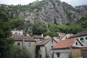 techos de casas y altas montañas en kotor, montenegro foto