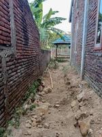 the side yard of the house with dry soil photo