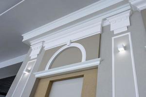 Detail of corner ceiling with intricate crown molding on column with spot light photo