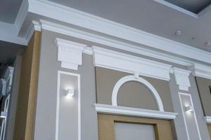 detalle del techo en esquina con intrincadas molduras de corona en una columna con luz puntual foto