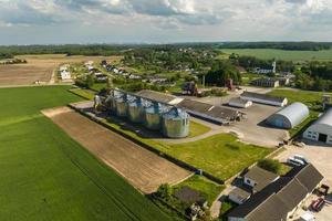 vista aérea sobre el elevador de granero de silos agrícolas en la planta de fabricación de procesamiento agrícola para el procesamiento de secado, limpieza y almacenamiento de productos agrícolas, harina, cereales y granos. foto