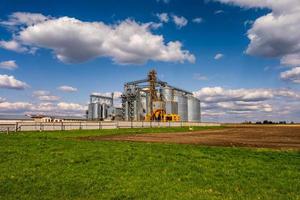 ascensor de granero moderno. silos de plata en la planta de procesamiento y fabricación de productos agrícolas para el procesamiento, secado, limpieza y almacenamiento de productos agrícolas, harina, cereales y granos. foto