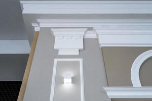 Detail of corner ceiling with intricate crown molding on column with spot light photo