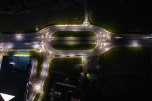 night over road junction, intersection road with cars with headlights on highway. night life in big city. looking down on traffic photo