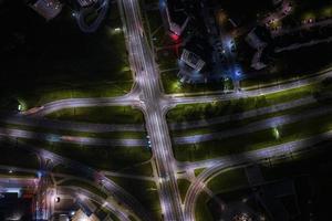 night over road junction, intersection road with cars with headlights on highway. night life in big city. looking down on traffic photo