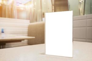 Restaurant table with mock up white sheets paper blank label menu frame acrylic stand photo