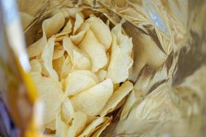 Potato chips in open snack bag close up photo