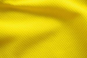 Yellow color football jersey clothing fabric texture sports wear background, close up photo