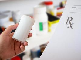 female pharmacist with prescription and medicine bottle at the pharmacy photo