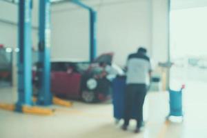 Mechanic working in car repair service centre blurred background photo