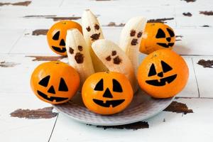 Painted funny faces on tangerines and bananas for Halloween photo