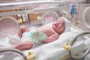 new born baby infant sleep in the incubator at hospital photo