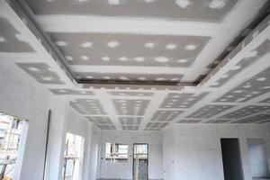 ceiling gypsum board installation at construction site photo