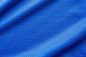 camiseta de fútbol de ropa deportiva de tela de color azul con fondo de textura de malla de aire foto