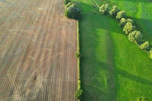 High angle view of cows grazing on field against sky. Gorgeous high angle aerial view of Animal Farm at British Agricultural Field Near London England Great Britain of UK photo