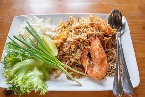 pad thai, fideos de arroz salteados con gambas de agua dulce servido con verduras, brotes y limón foto