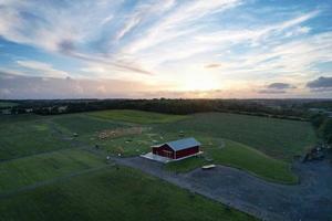 High angle view of cows grazing on field against sky. Gorgeous high angle aerial view of Animal Farm at British Agricultural Field Near London England Great Britain of UK photo