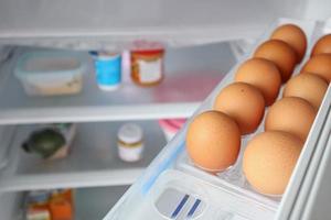 los huevos se organizan en el estante del refrigerador foto