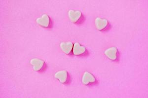 valentine candy hearts shape on pink background photo