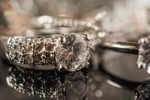 anillos de diamantes de joyería de lujo con reflejo en el fondo negro foto