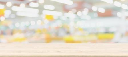 Wood table top with blur grocery store background with bokeh light photo