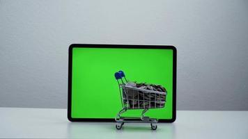 stop motion um carrinho de compras movendo-se ao redor da tela verde do tablet. video