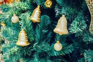 Decorated golden bell on Christmas tree photo