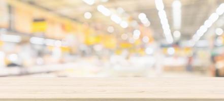 Wood table top with blur grocery store background with bokeh light photo