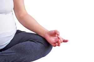 Mujer embarazada haciendo yoga aislado sobre fondo blanco. foto