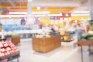 Supermarket with fresh fruits and vegetable on shelves in store blurred background photo