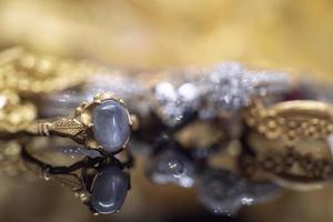 Vintage gold Jewelry blue sapphire rings with reflection on black background photo