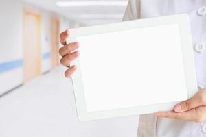 médico que muestra una tableta digital con pantalla en blanco en el hospital foto