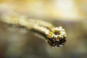 pulsera de joyería de oro de lujo con reflejo en el fondo negro foto