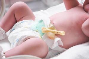 Newborn baby girl inside incubator in hospital post delivery room photo