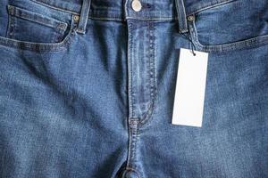 Blue jeans with blank white price label tag photo