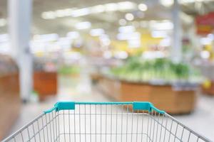 Shopping cart with Supermarket with fresh food abstract blurred background with bokeh light photo