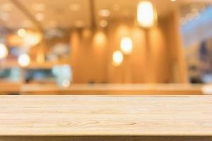 wood table with abstract blurred cafe restaurant with bokeh lights defocused background photo