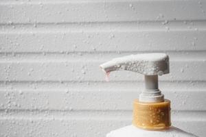 gota de agua en la bomba dispensadora de jabón líquido durante el baño foto