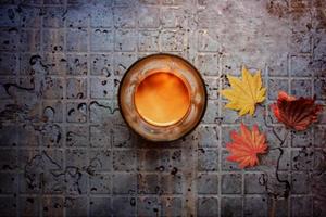 Drinking Coffee in Fall and Autumn Season. Hot Coffee Latte Cup on Wooden Table. Top View. Selective Focus. blurred Maple Leaf as background photo